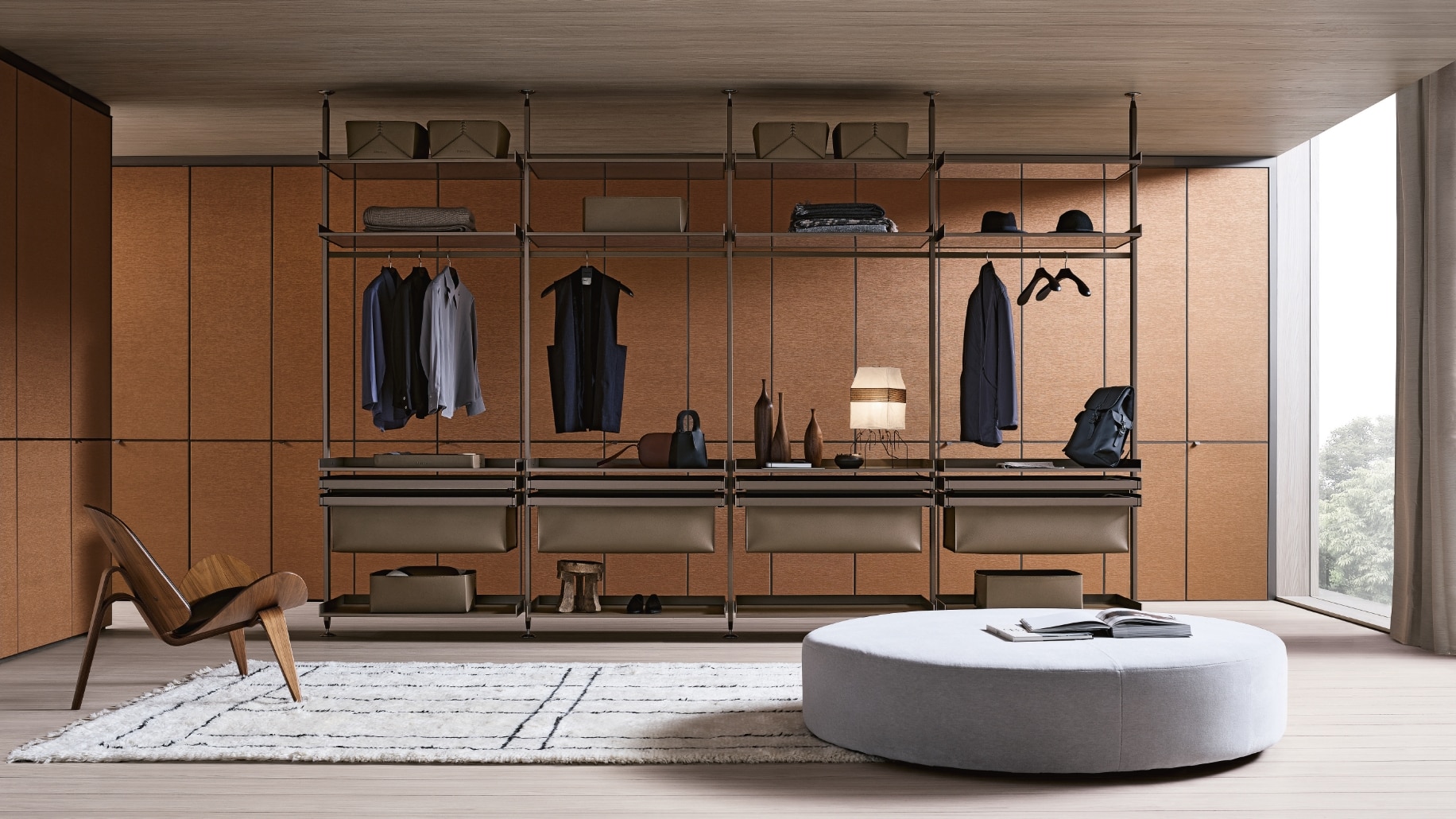 Zenit Walk-in Closet van Rimadesio, gekarakteriseerd door een modulaire opstelling met een verfijnde combinatie van leer en glasafwerkingen. De kast biedt ruime opbergruimte met stijlvolle planken voor kleding en accessoires, terwijl de open structuur de lichte, moderne uitstraling van de kamer versterkt. De kast is zorgvuldig ontworpen met premium materialen en is geïntegreerd met een minimalistisch meubelontwerp dat de ruimte visueel vergroot. Het luxe ontwerp wordt geaccentueerd door de warme houttinten van de achterwand, die samen met de zachte verlichting een elegante sfeer creëert in het interieur.